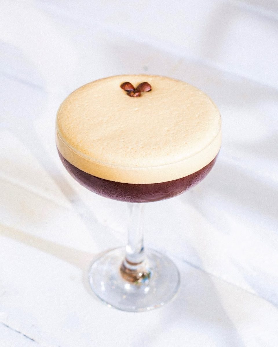 An espresso martini with three coffee beans on top