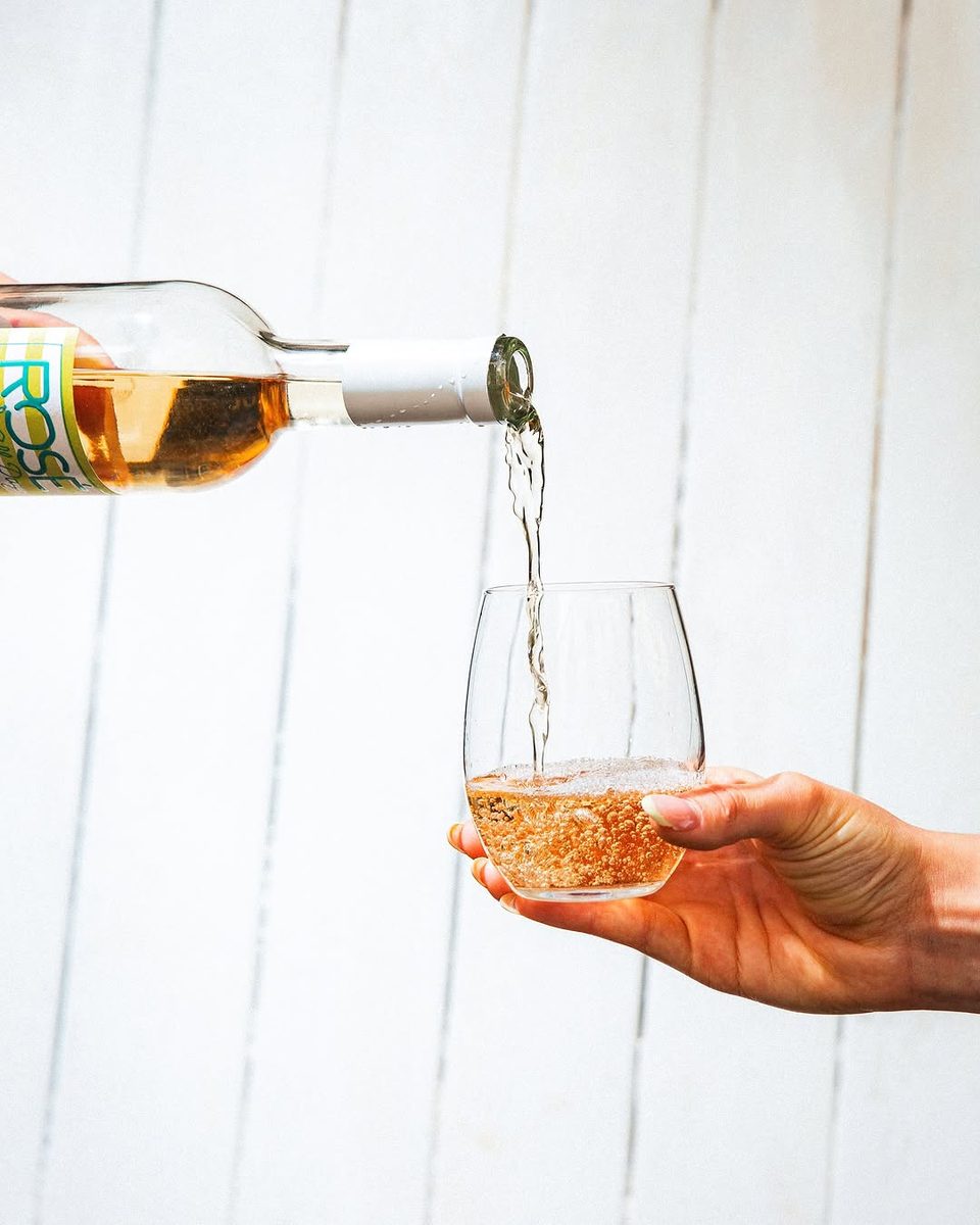 Rosé being poured into a glass held up to the light