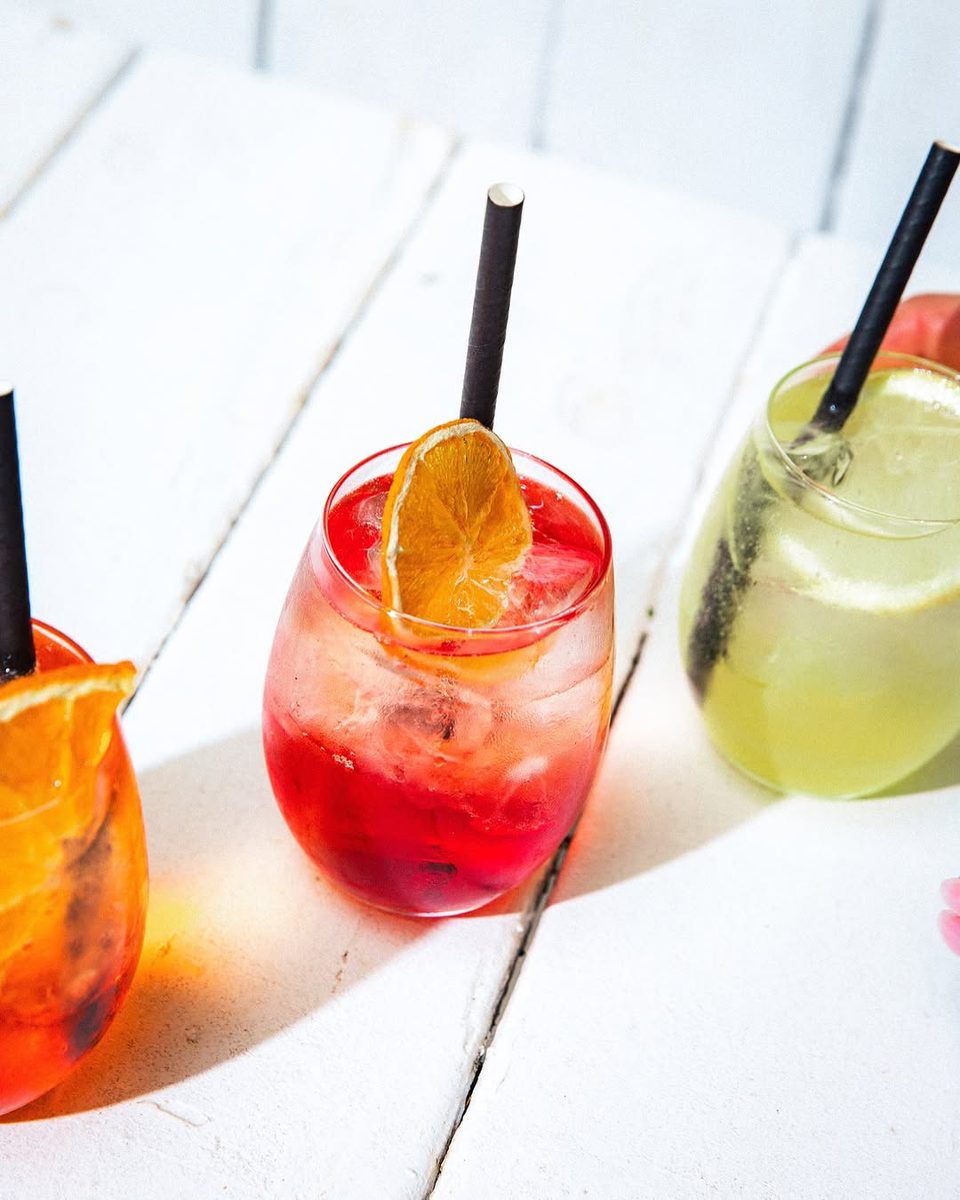 Aperol, Campari and limoncello spritzes lined up in the sun